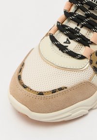 Sneaker testurizzato con tomaia in rete beige, accenti in suede marrone chiaro, dettagli con stampa leopardata e lacci neri con motivo geometrico.