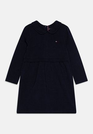 Tumesinine pikkade käistega kleit, millel on ümar kaelus, kogutud seelik ja rinnal väike logo aktsent. Pehme, kergest puuvillast materjal.