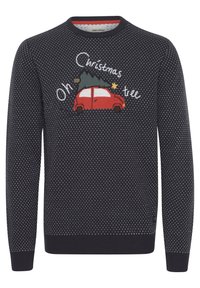 Maglione blu scuro con pois bianchi, un'auto rossa ricamata con un albero di Natale e testo che recita "Oh albero di Natale."