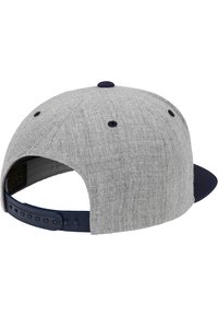 Grå stofflue med en marineblå skjerm, snapback-lukking, teksturert overflate og to ventilasjonshull på toppen.