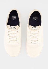 Leichte cremefarbene Canvas-Sneaker mit Netzpaneelen, runden Zehen, flachen Schnürsenkeln und einer kontrastierenden marineblauen Innensohle. "REEF"-Markenlogo auf der Zunge.
