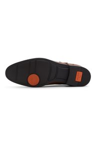 Suela de zapato de goma negra con agarre texturizado, que presenta un acento circular naranja y el logo "ALDO flex" en el lateral.