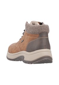 Stivale alla caviglia in pelle marrone con un polsino in tessuto marrone texture, suola beige e accenti scuri. Presenta una punta arrotondata e chiusura con lacci.