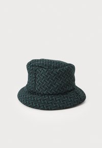 Hattu ämpäri, joka on valmistettu tumman teal-värisestä kankaasta ja jossa on kudottu kuvio. Suunnittelussa on jämäkkä yläosa ja leveä, tasainen lippa.
