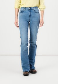 Light blue denim jeans with a high waist, flared legs, subtle distressing on the thigh, and standard five-pocket design.