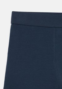 Navy modré bavlněné boxerky s měkkým pasem, hladkou texturou a jemnými švy po stranách.