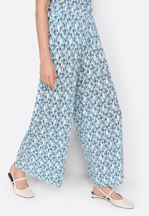 Floral wide-leg pants with a white and blue pattern, featuring a smocked waistband. Paired with cream flats.
