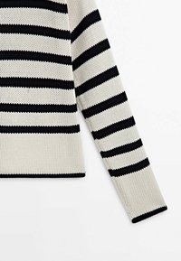 Pull en maille à manches longues avec des rayures horizontales noires et blanches, montré de la taille jusqu'à la fin d'une manche.
