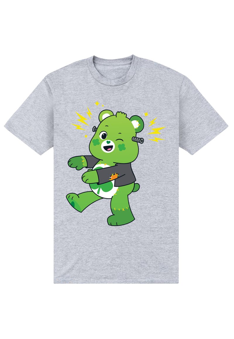 Camiseta gris con un oso verde de dibujos animados con una expresión alegre, que lleva una chaqueta negra con acentos de relámpago amarillos y un diseño de trébol.