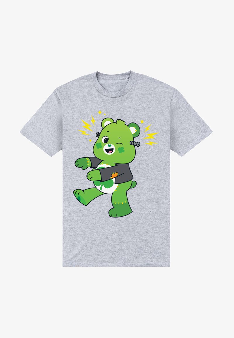 Camiseta gris con un oso verde de dibujos animados con una expresión alegre, que lleva una chaqueta negra con acentos de relámpago amarillos y un diseño de trébol.