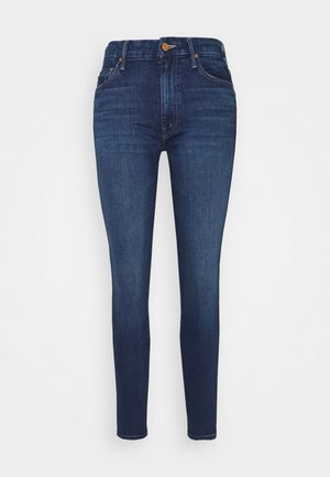 Tumma siniset slim fit -farkut, joissa on korkeavyötärö, viiden taskun malli, kontrastiväriset saumat ja edessä nappikiinnitys.