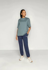 Ljusblå kortärmad t-shirt som är kombinerad med mörkblå joggers; har en avslappnad passform och sidofickor. Avslutas med vita sneakers.