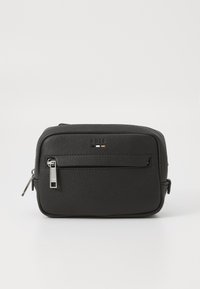 Schwarze Leder-Tasche mit strukturierter Oberfläche, Hauptfach mit Reißverschluss und Fronttasche. Besitzt ein minimalistisches Logo in Weiß und orangenen Akzenten.