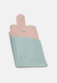 Lädernyckelhållare med en mintgrön nederdel och en mjuk rosa överdel. Har ett tryckknappslås och präglad logotyp. Stygn detaljer ger textur.