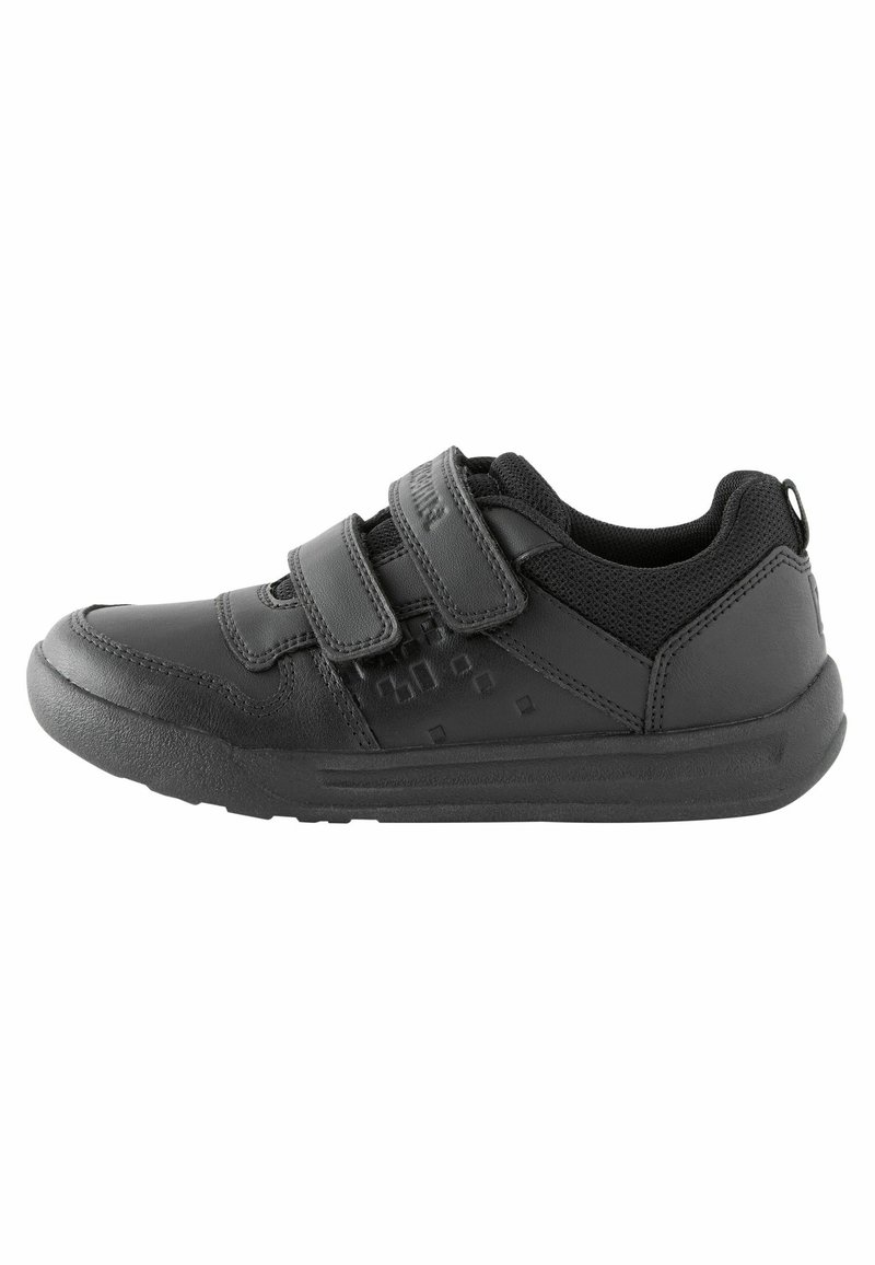 Chaussure de sport noire en matériau synthétique avec des bandes Velcro, un embout texturé et des empiècements en maille pour une meilleure respirabilité. Semelle en caoutchouc plate.