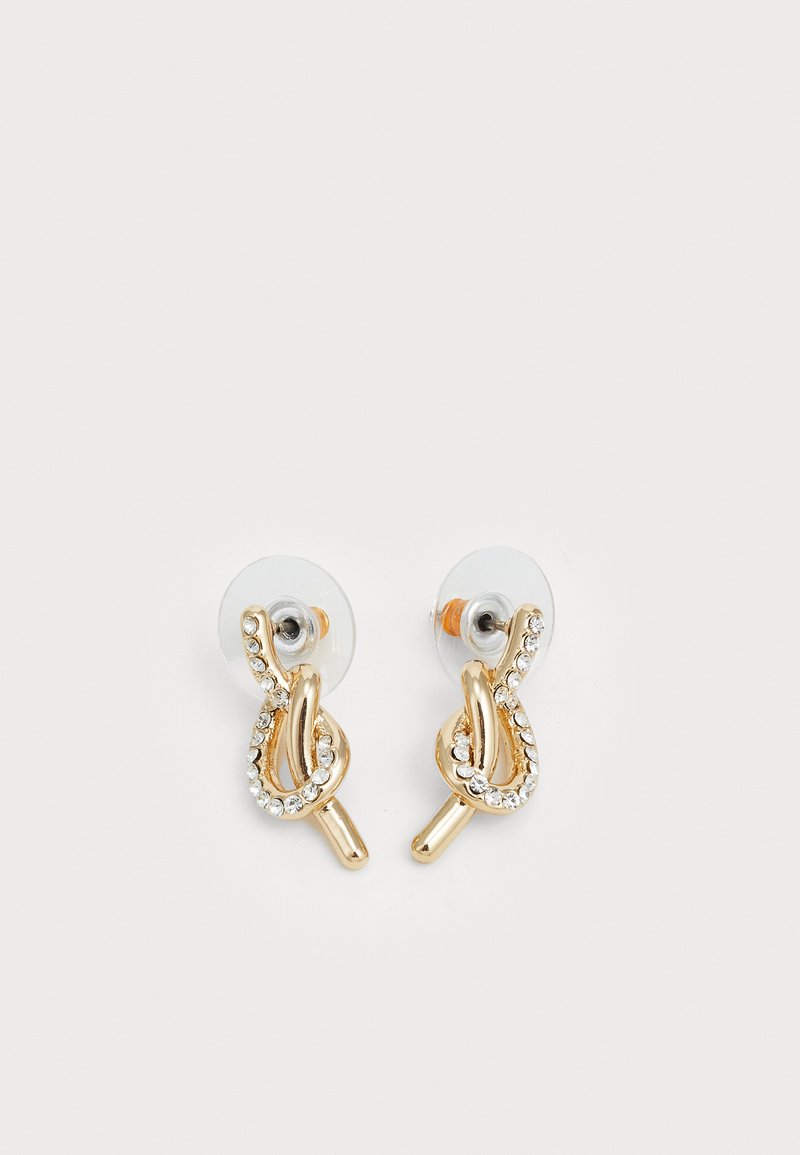 Orecchini dorati con un design attorcigliato e strass trasparenti lungo i cerchi, fissati con retro trasparenti per un look discreto.