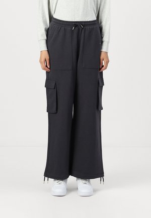 Pantaloni cargo neri a gamba larga con due tasche anteriori, vita con cordoncino e orli con zip. Realizzati in tessuto morbido, ideali per un look casual.