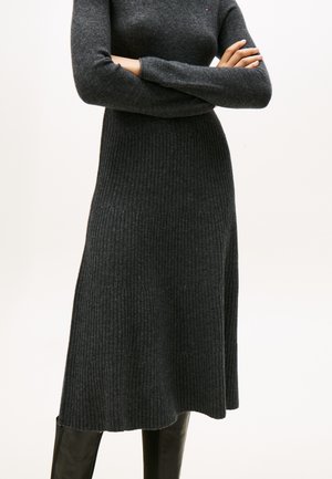 Dunkelgrau gestricktes Kleid mit einem taillierten Oberteil und ausgestellt Rock, mit langen Ärmeln und rundem Ausschnitt. Keine sichtbaren Beschläge oder Akzente.
