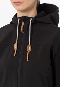 Chaqueta negra con capucha y cremallera frontal, con detalles en cuero beige y cordones blancos. Textura suave y diseño ajustado.