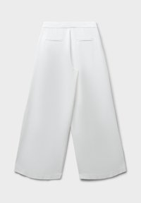 Pantalons larges blancs à la texture lisse, taille mi-haute et deux poches arrière. Fini avec une ceinture nette et des bords soignés.