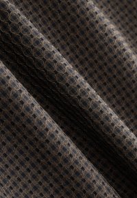 Textured fabric featuring a hexagonal pattern in dark brown and black tones, with visible weaving and a soft, slightly fuzzy surface.