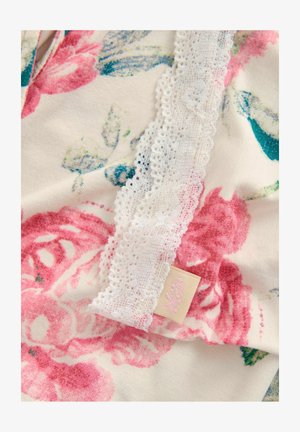 Tessuto a fantasia floreale in toni di rosa e blu, con delicato bordo in pizzo bianco e una piccola etichetta con design floreale. Morbida al tatto.