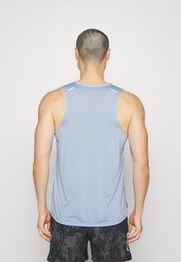 Light blue athletic tank top with a round neckline, sleeveless design, and reflective accents on the shoulders. Smooth, moisture-wicking fabric.
