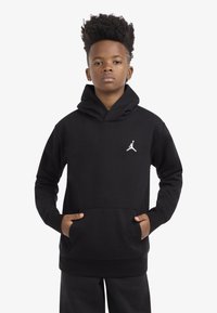 Black hoodie made of soft fabric, featuring a kangaroo pocket, ribbed cuffs, and a white Jumpman logo on the chest.
