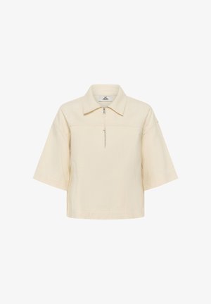 Krém színű rövid ujjú ing gallérral és elöl fél cipzárral, laza szabással és ereszkedő vállvonalakkal.