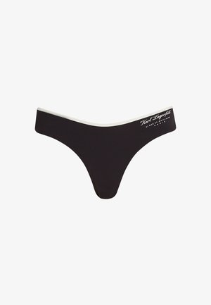 Zwarte stringonderbroek met een contrasterende witte elastische tailleband. Kenmerkt zich door een textuurstof en een bedrukte merklogo op de tailleband.