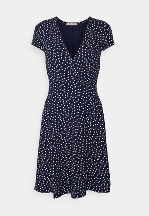 Robe bleu marine à manches courtes avec des pois blancs irréguliers, col en V, taille cintrée et jupe évasée.