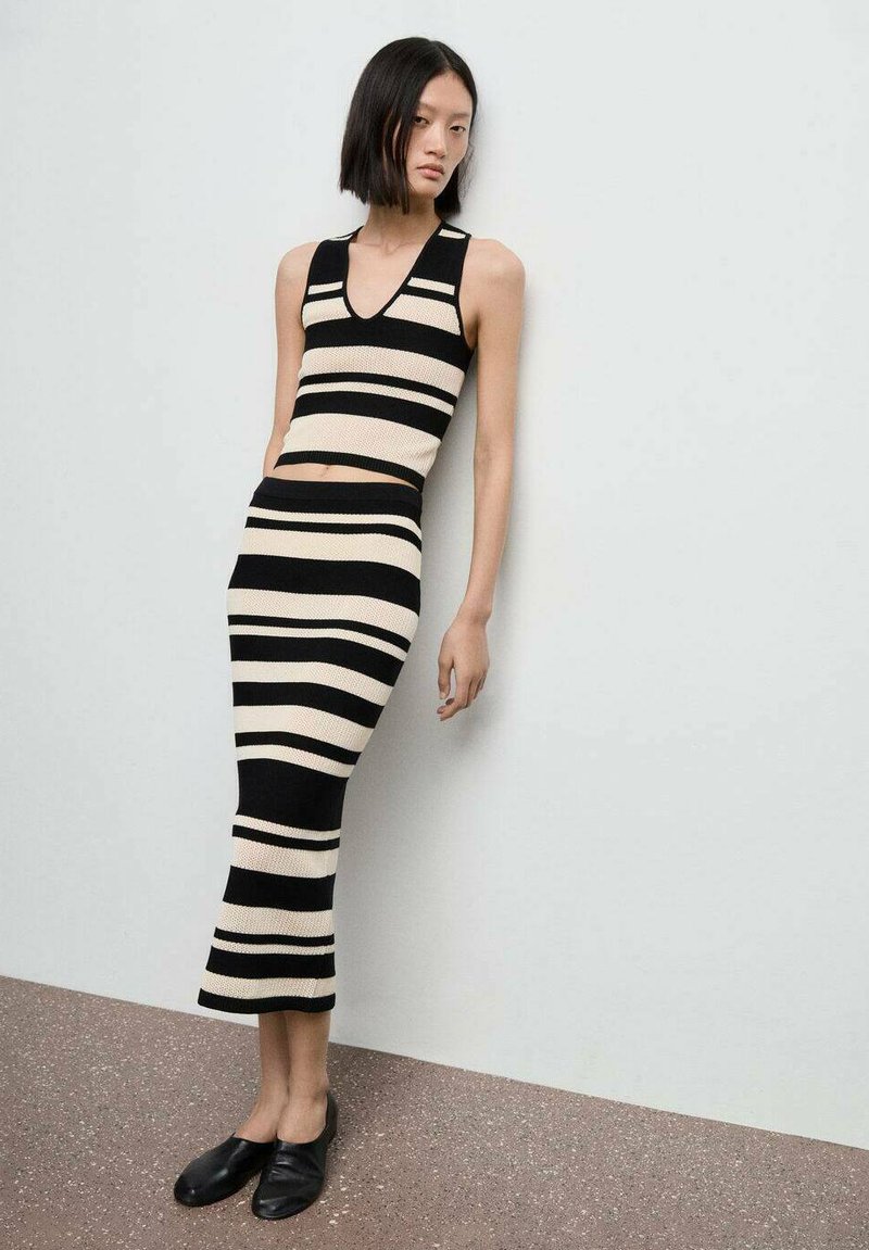 Zwart en crèmekleurig gestreept gebreid twee-stuks outfit met een mouwloze crop top en een rok tot de knie. Zachte textuur en aansluitend ontwerp.