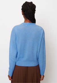 Hellblau gestrickter Pulli mit Rundhalsausschnitt und langen Ärmeln, der eine leicht verkürzte Silhouette und eine weiche Textur aufweist.