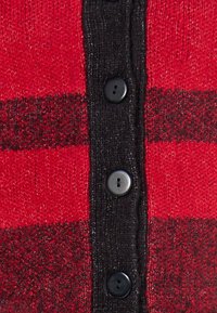 Röd och svart rutig cardigan med en strukturerad stickning, med en svart knäppning framtill och kontrasterande färgband.