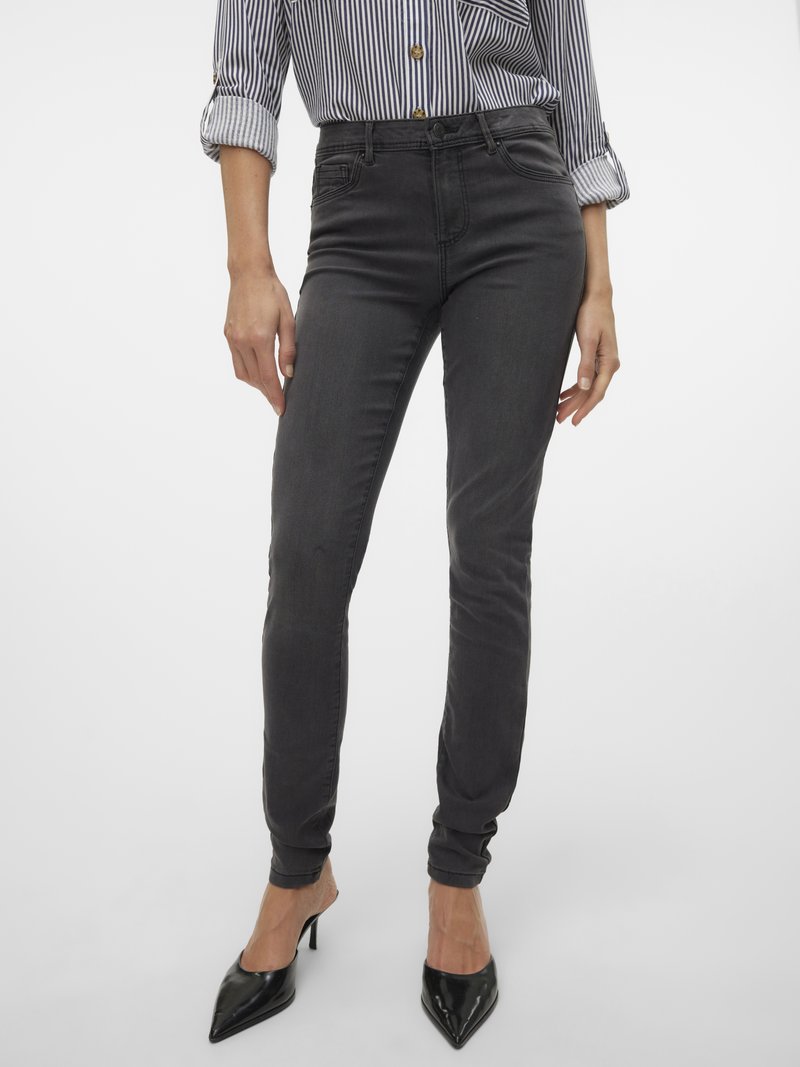 Sötétszürke, vékony farmer pamutkeverékből, sima textúrával. Csíkos inggel és fekete, hegyes orrú magas sarkú cipővel kombinálva.