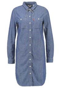 Vestito camicia in denim con maniche lunghe, colletto, due tasche sul petto, chiusura con bottoni e dettaglio con lacci sul collo. Blu chiaro, texture liscia.