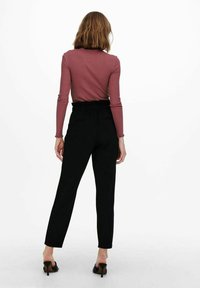 Langsleeve, geribbelde bordeaux rode blouse met een aansluitend ontwerp, gecombineerd met hoog getailleerde zwarte broeken met een ontspannen pasvorm en twee achterzakken.