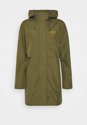 Impermeable con capucha de color verde oliva, con cordones ajustables, cierre delantero con cremallera oculto bajo solapa y logo amarillo en el lado izquierdo del pecho.