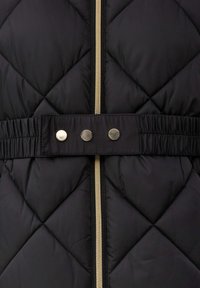 Veste rembourrée matelassée noire avec une fermeture éclair dorée, une taille ajustable avec des boutons-pression argentés et une texture de tissu douce.