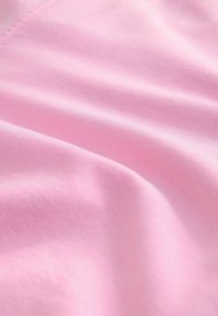 Roze stof met een gladde textuur en een lichte glans, voorzien van een subtiel weefpatroon. Zacht, lichtgewicht en kreukbestendig materiaal.