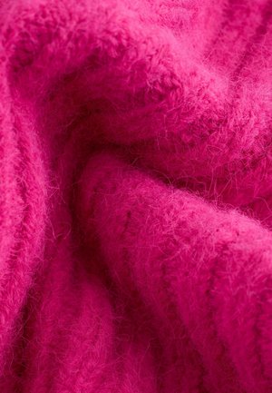 Tissu rose doux et duveteux avec une texture côtelée, affichant une teinte riche et des fibres visibles. Convient pour des vêtements ou des articles confortables.