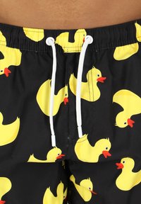 Zwemshorts met een zwarte achtergrond en een patroon van gele rubberen eenden, witte trekkoord en een gladde textuur.