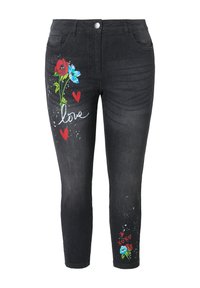Jeans ajustados negros con estampados florales en rojo y azul, que presentan corazones y la palabra "amor" en blanco. Elaborados en denim con una textura suave.