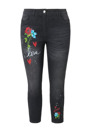 Jeans skinny noirs avec des motifs floraux en rouge et bleu, comportant des cœurs et le mot "amour" en blanc. Fabriqués en denim avec une texture lisse.