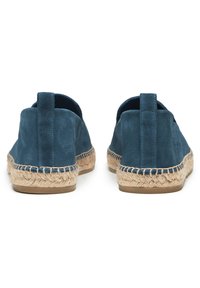 Espadrilles en suède bleu avec une semelle et un dos en corde de jute. La vue de l'arrière montre deux languettes et une texture douce avec une forme arrondie.