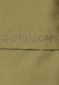 Olive zielony materiał z beżowym haftowanym napisem "DIDRIKSONS" wyśrodkowanym na tkaninie.