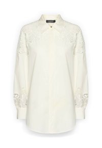 Crèmewitte blouse met lange mouwen, kantdetails op de schouders en manchetten, puntige kraag en verborgen knopen aan de voorkant.