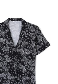 Camicetta a maniche corte in tessuto nero con motivo paisley bianco, colletto fessurato e chiusura con bottoni. Texture liscia e vestibilità rilassata.