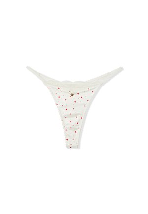 Weiße String-Unterwäsche mit roten Herzmustern, Spitzenbesatz und einem kleinen Metallherzanhänger. Weicher Stoff mit glatter Textur.