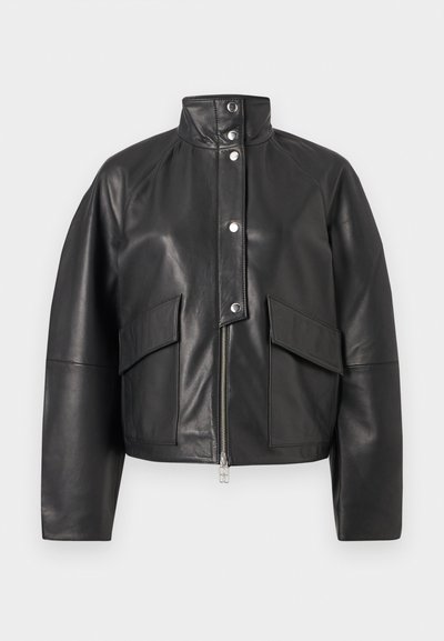 Μαύρο δερμάτινο μπουφάν με ψηλό γιακά, μπροστινό φερμουάρ, κουμπιά κούμπωμα με κρίκο και δύο μεγάλες τσέπες με καπάκι μπροστά, σε μονόχρωμο φόντο.